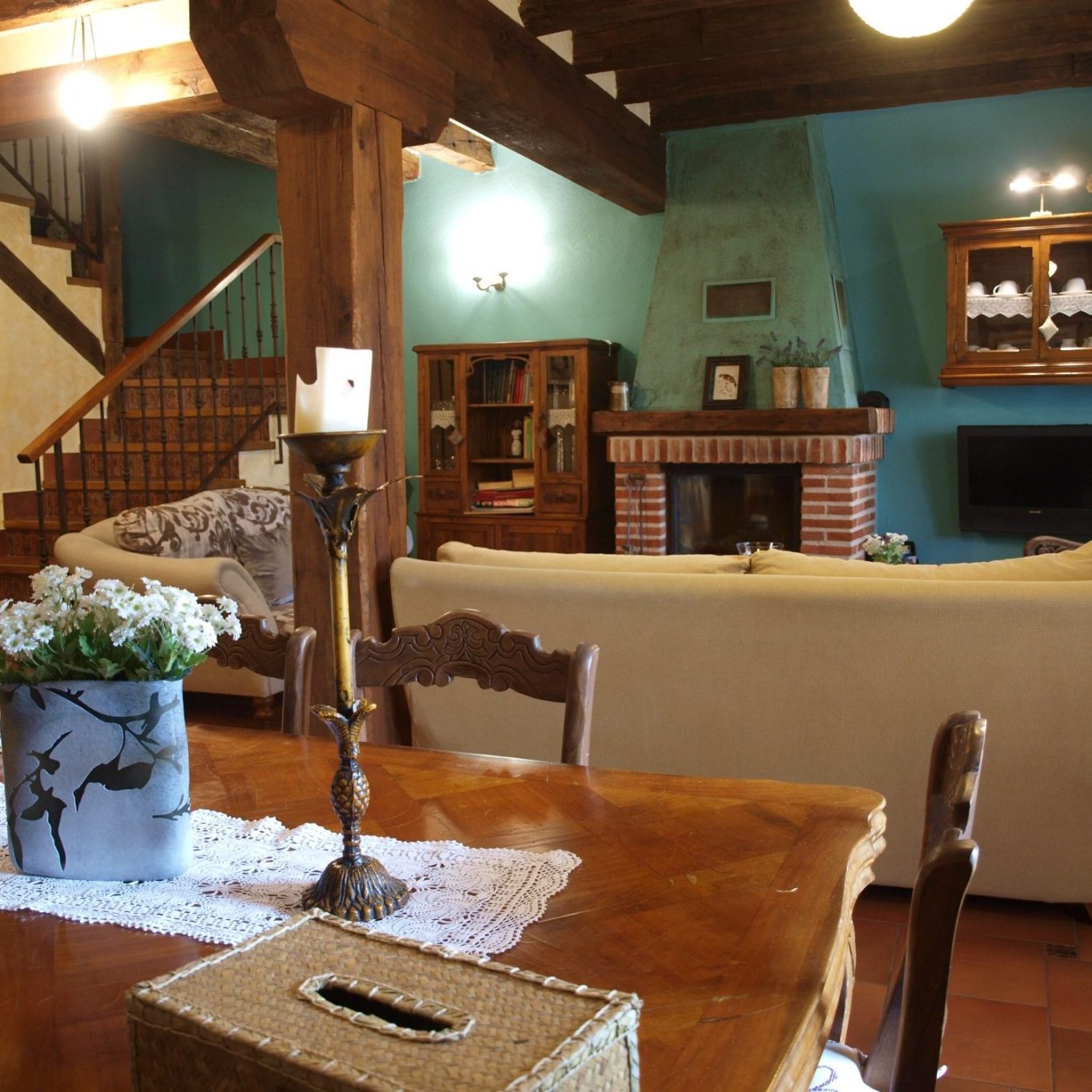 Salón rústico acogedor con chimenea de leña y sofás cómodos para grupos en Segovia Sala de estar acogedora con muebles de madera, chimenea y decoración rústica.